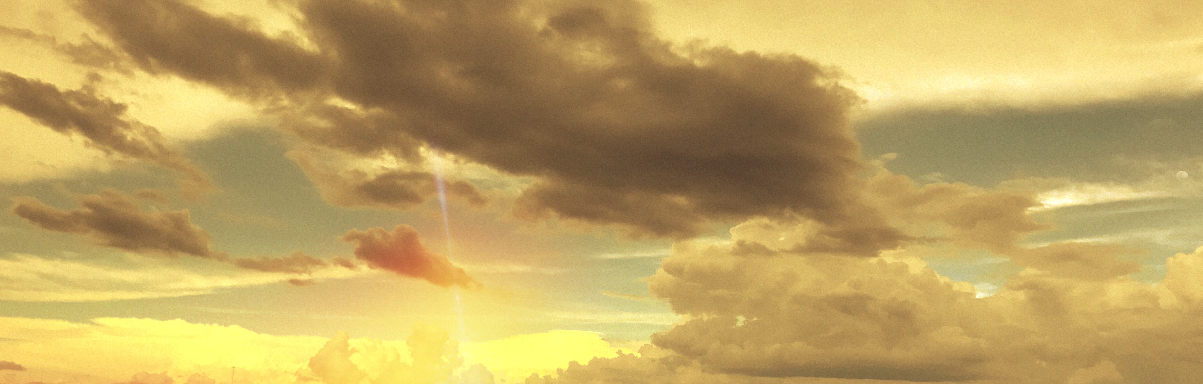 a finger of light through yellow-gray clouds